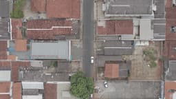 Rua residencial com casas geminadas e carro branco