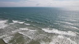 Surfistas enfrentam ondas em mar aberto