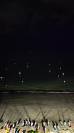 Barcos coloridos iluminados à noite na praia - Pajuçara