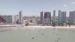 Praia urbana com barcos e arranha-céus
