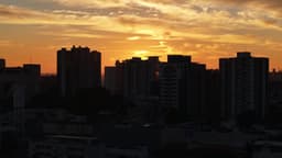 Pôr do sol dourado entre prédios urbanos