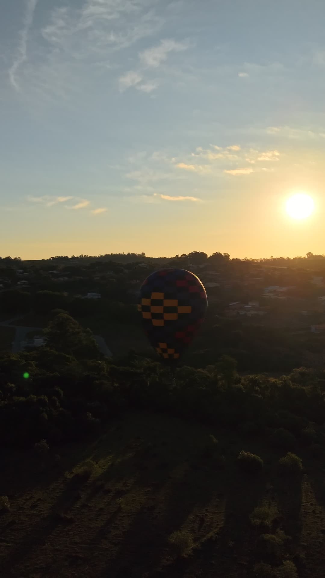 Balão colorido sobrevoando ao pôr do sol