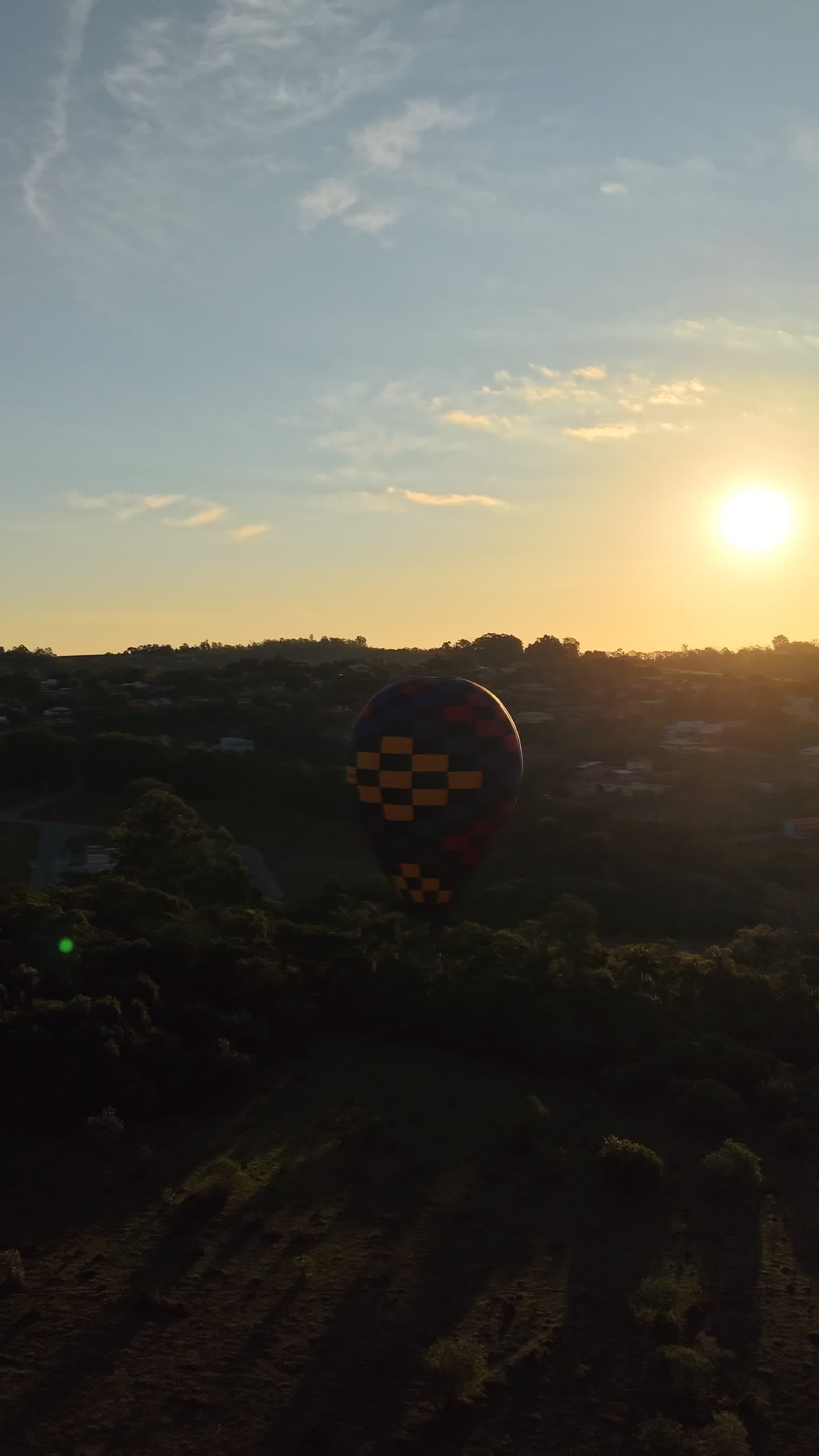 Balão colorido sobrevoando ao pôr do sol