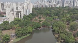 Parque urbano com lago e skyline ao fundo