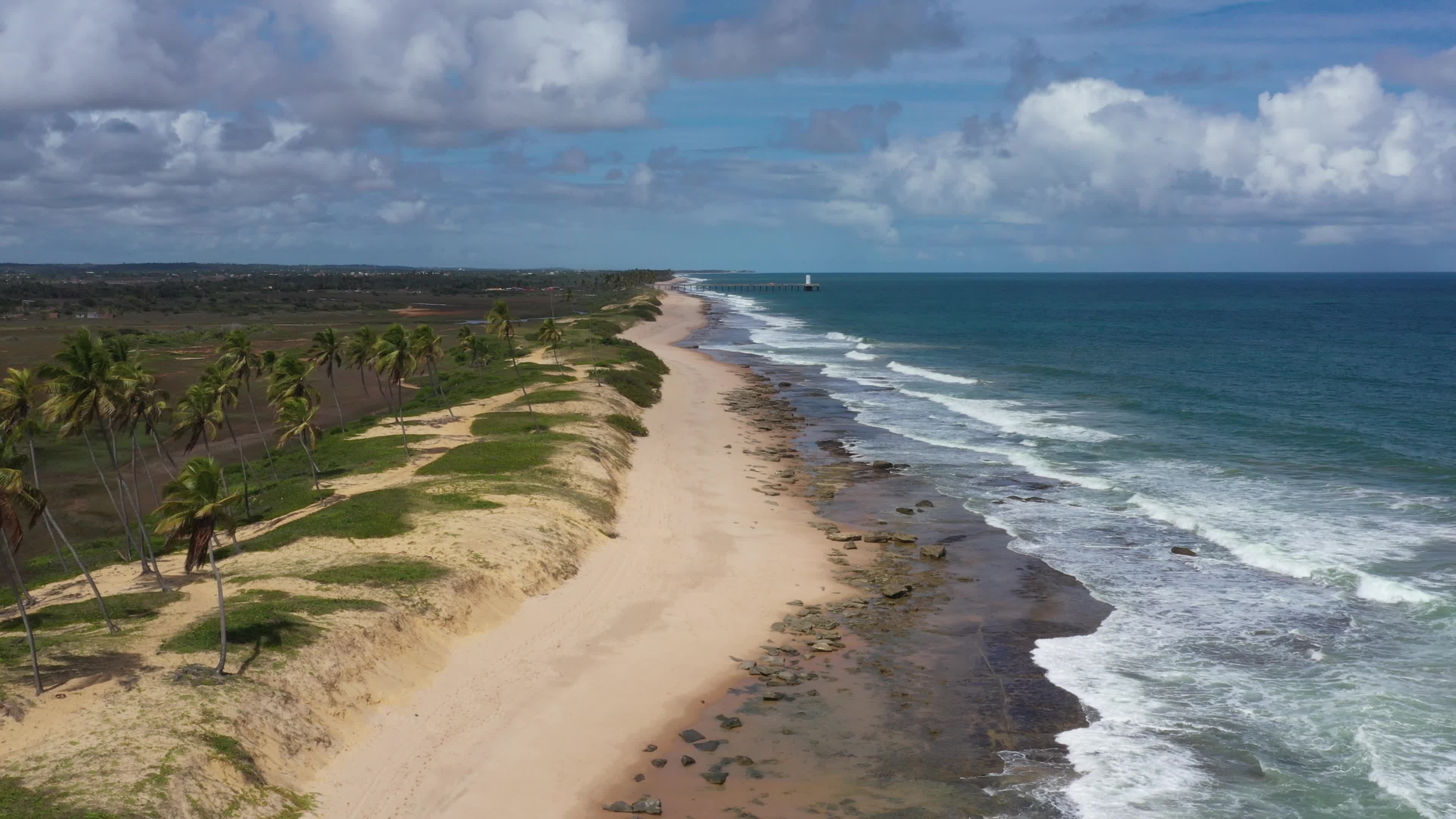 Praia deserta com coqueiros e mar cristalino