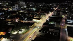 Avenida movimentada em bairro de cidade grande noturno