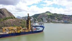 Navio atracado no porto de Vila Velha em foco. Ao fundo o Penedo e a cidade de Vitória.