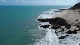 Praia deserta com rochas à beira-mar