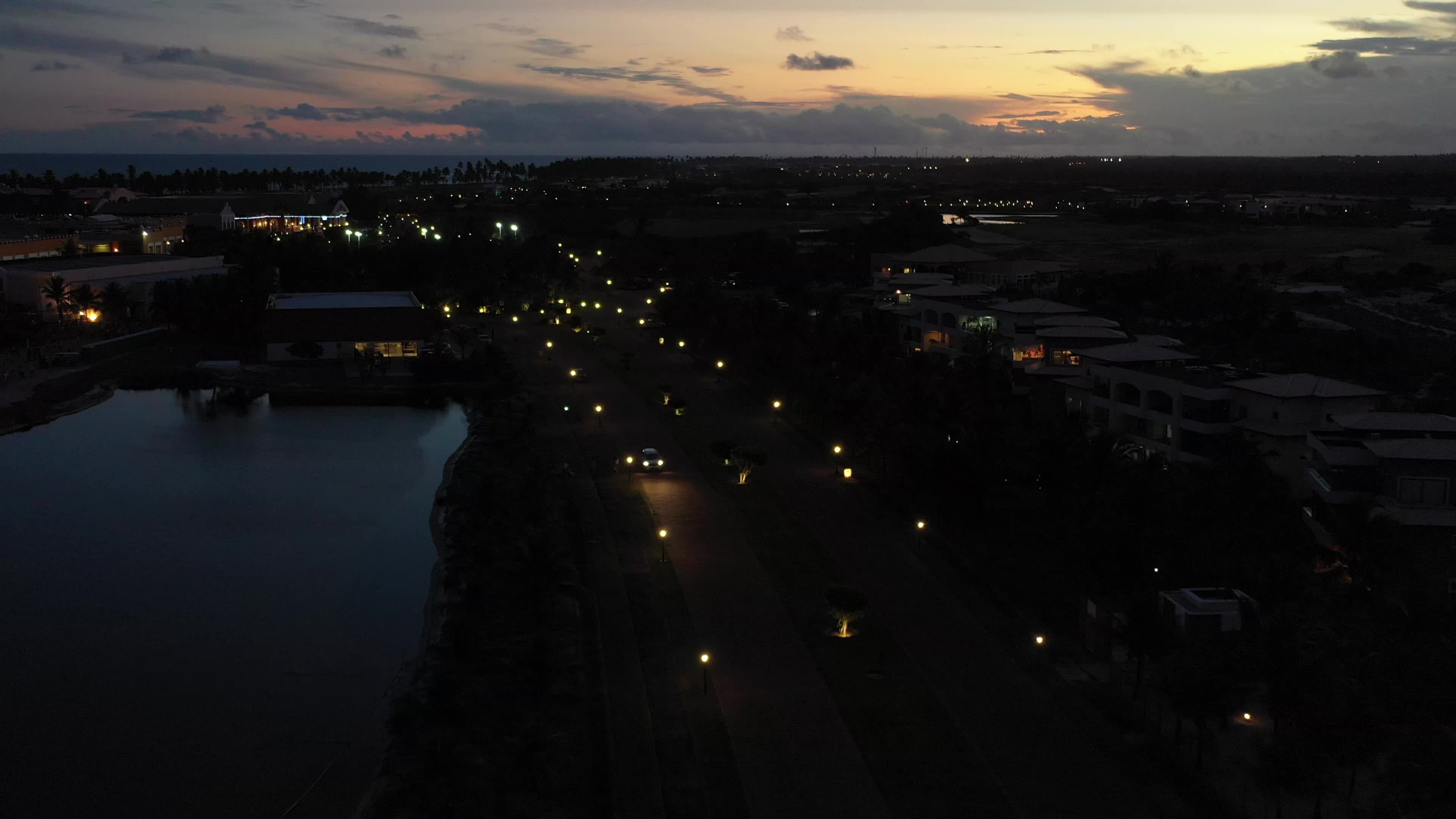 Avenida iluminada ao entardecer junto ao lago