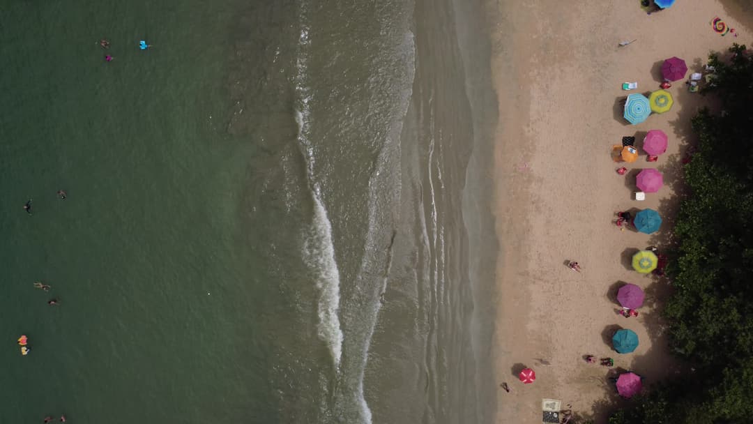 Vista de cima (zenital) da Praia do Alto em Ubatuba - Mar e Guarda-sóis coloridos