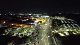Centro iluminado com avenida movimentada à noite