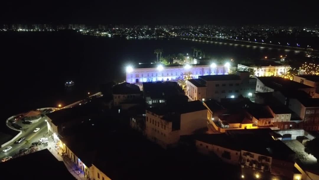 Centro histórico iluminado à beira-rio à noite
