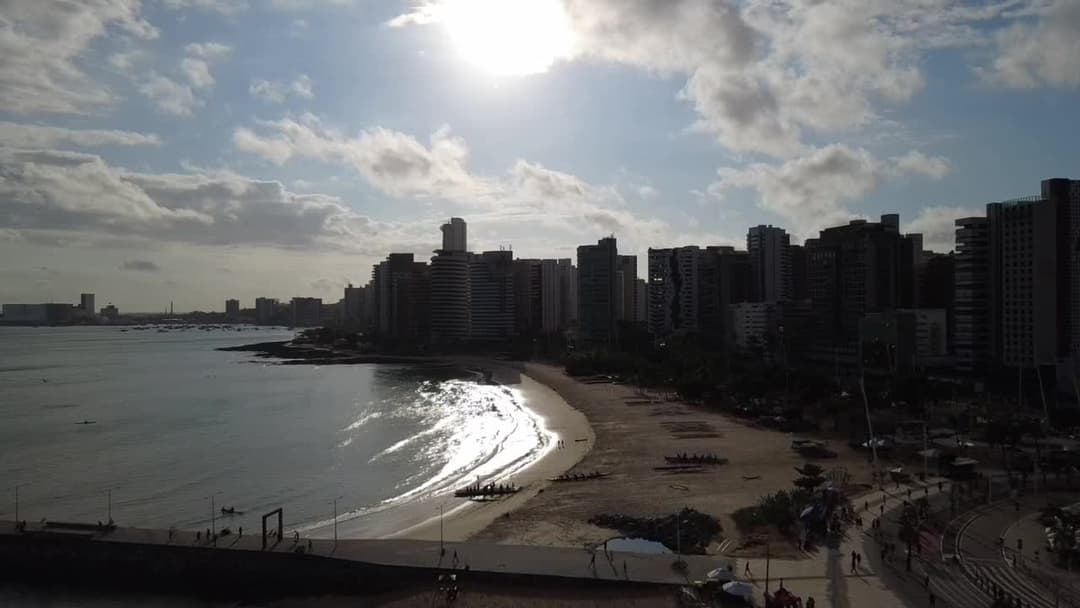 Praia urbana iluminada pelo sol nascente 