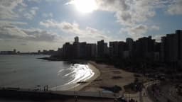 Praia urbana iluminada pelo sol nascente 