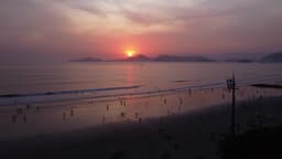 Pôr do sol vibrante na praia movimentada em santos, sao paulo