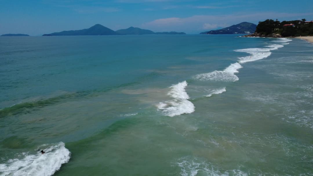Banhistas no mar azul da Praia Vermelha do Centro, Ubatuba - Vista Aérea