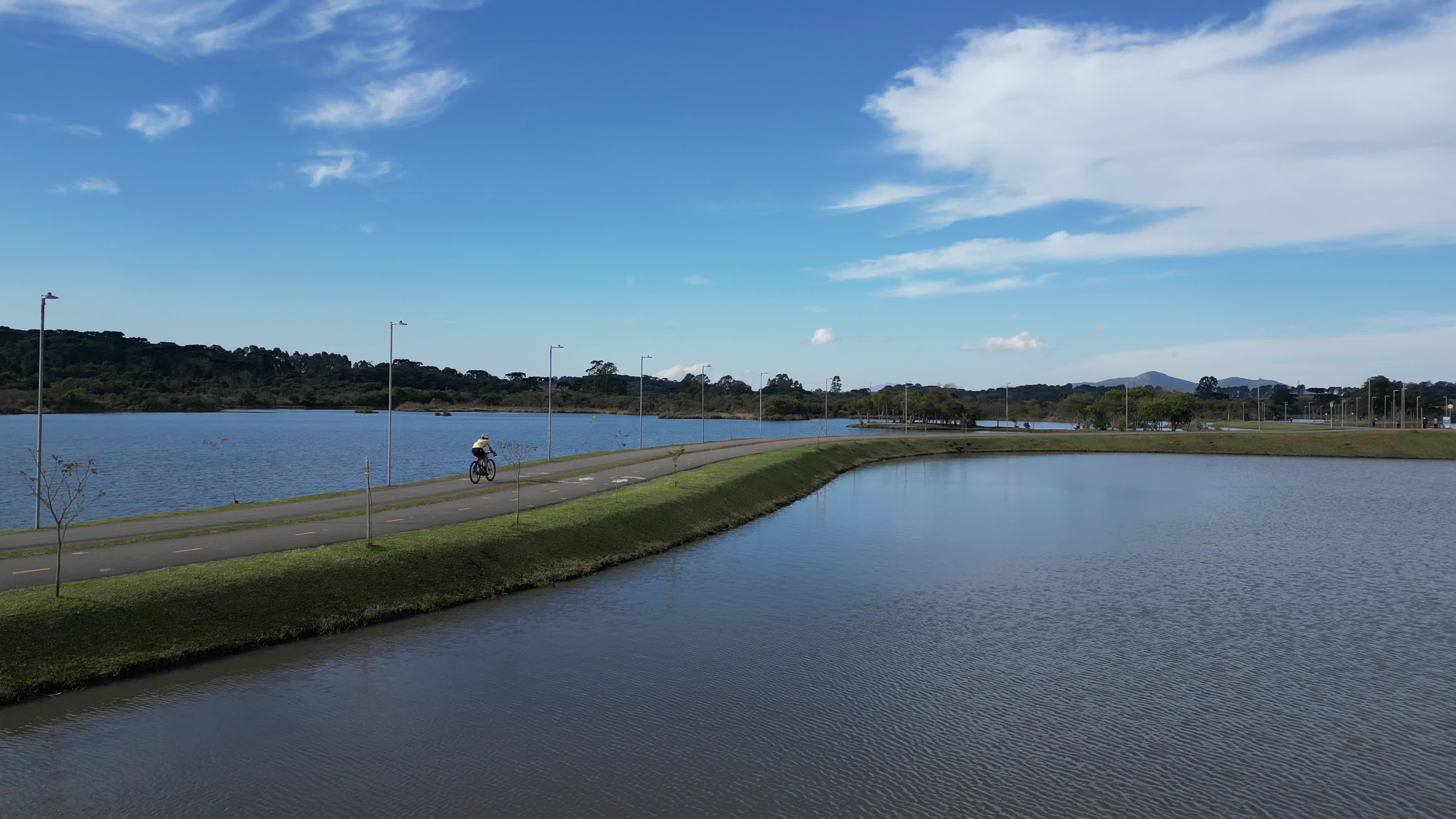 Ciclovia à beira do lago em dia ensolarado CICLISTA