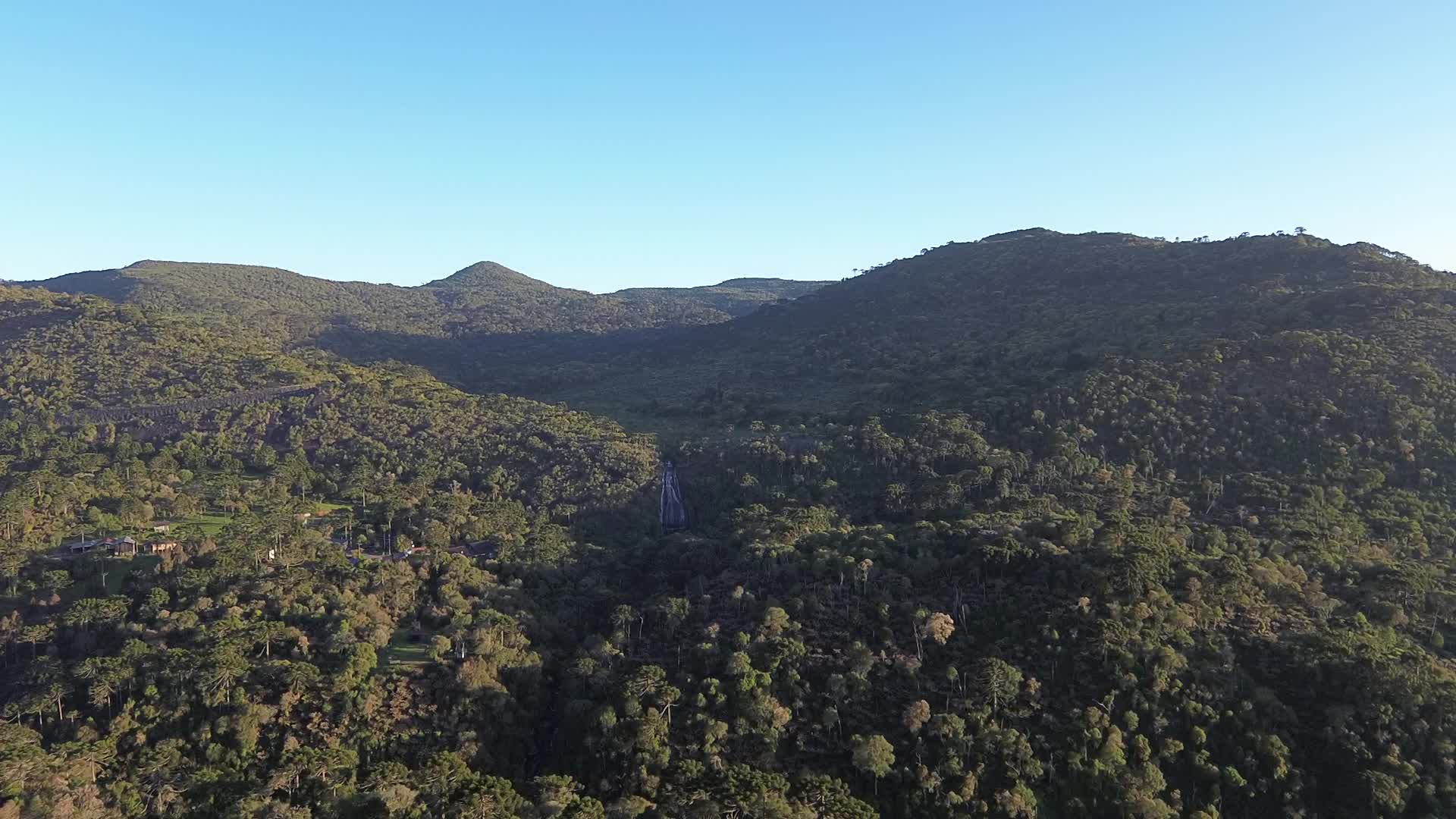 Sobrevoo saindo de um chalé com vista para o morro da igreja e a cascata veu de noiva