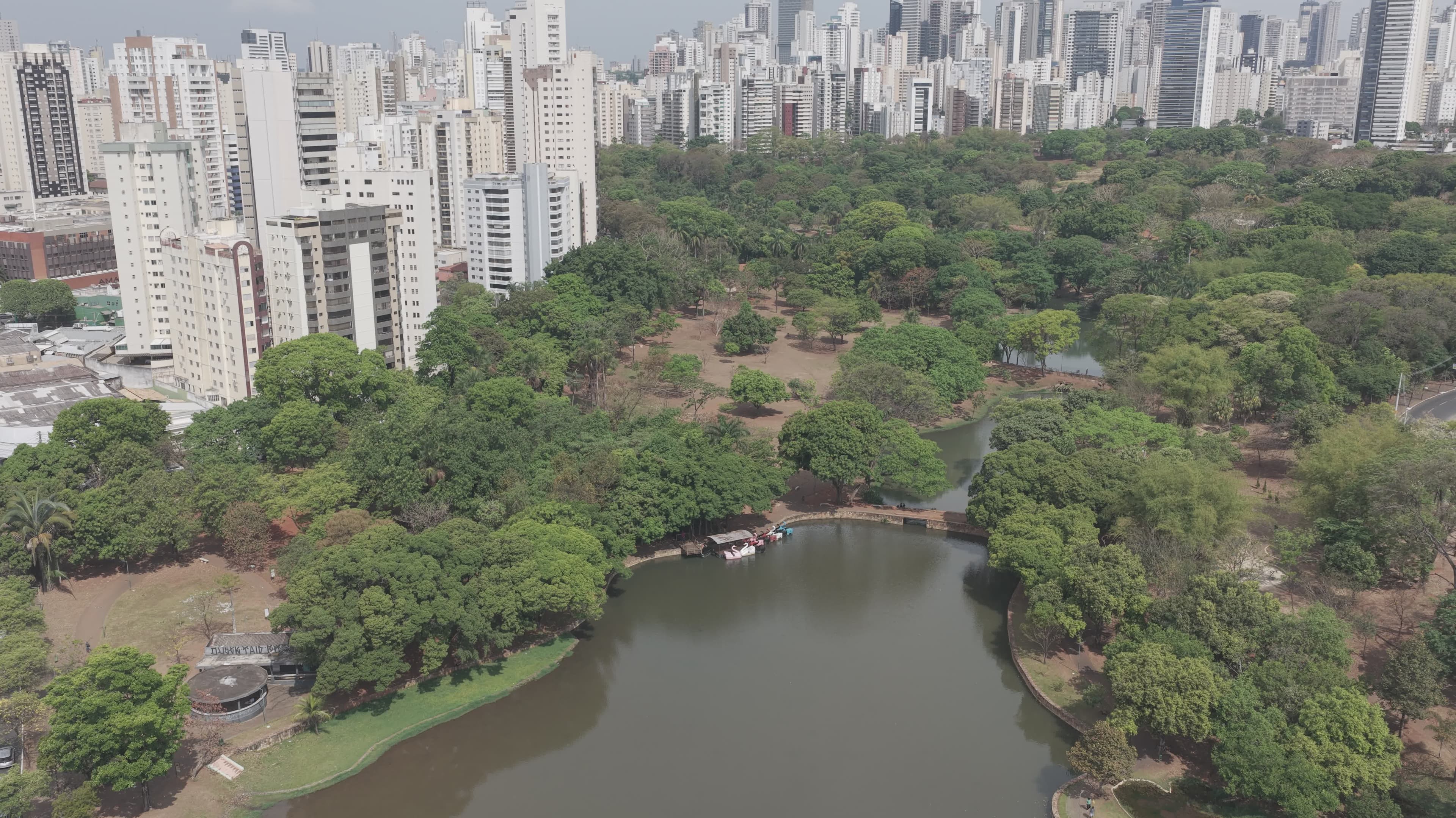 Parque urbano com lago e skyline ao fundo
