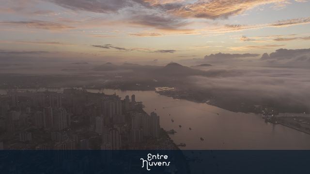 Amanhecer com neblina sobre rio e cidade canal do porto em Santos