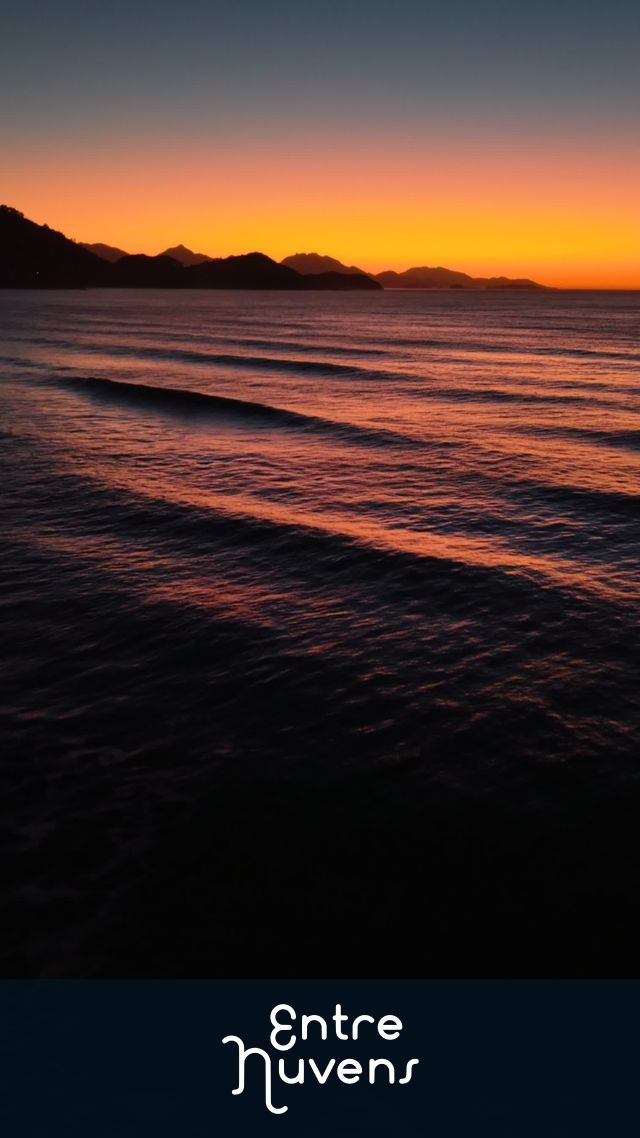 Amanhecer espetacular na praia: mar calmo e céu alaranjado — vídeo aéreo de Ubatuba
