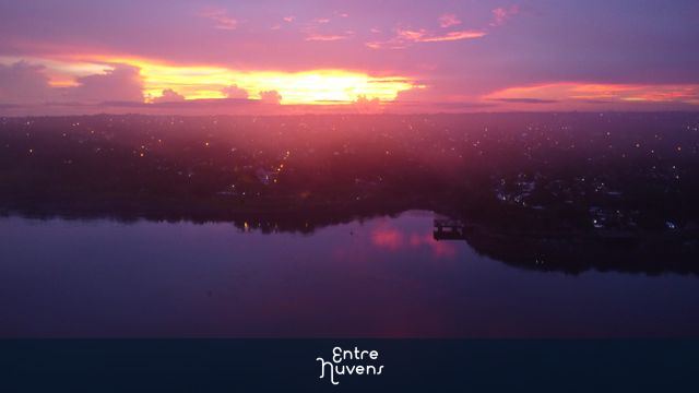 Amanhecer vibrante sobre o rio e a cidade