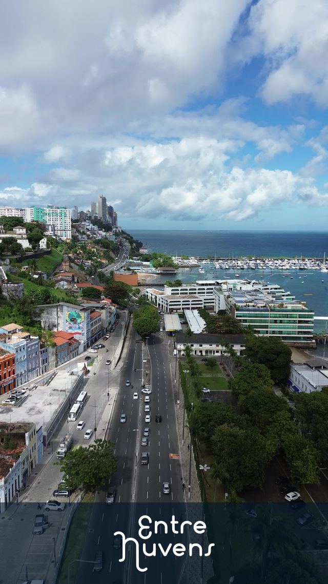 Avenida à beira-mar com marina e cidade ao fundo