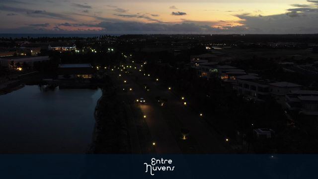 Avenida iluminada ao entardecer junto ao lago — vídeo aéreo de Mata de São João