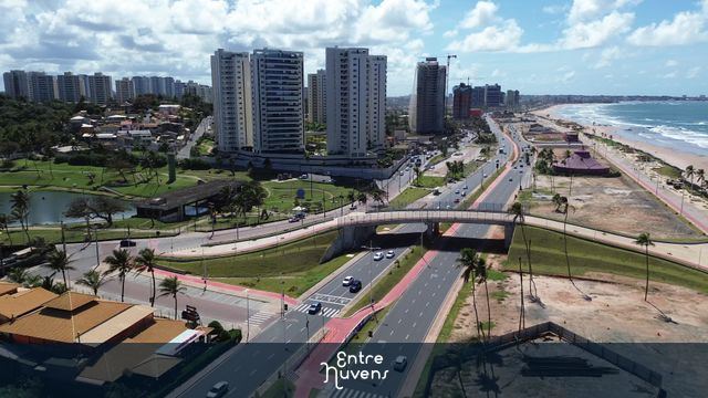 Avenida litorânea com prédios e praia azul