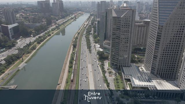 Avenida movimentada entre prédios e rio