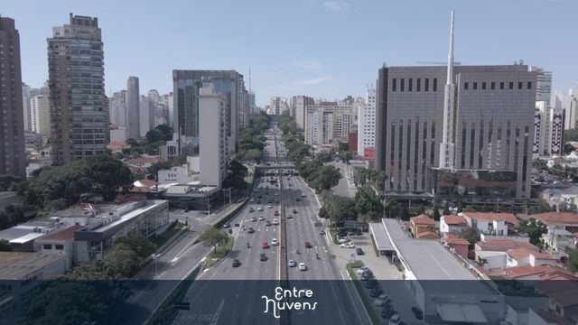 Avenida movimentada entre prédios modernos