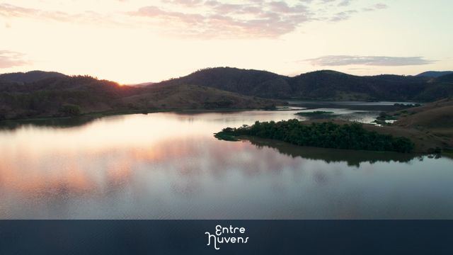Backward Drone Flight Over Paraíba do Sul River at Sunset Revealing Riverbank — vídeo aéreo de Três Rios