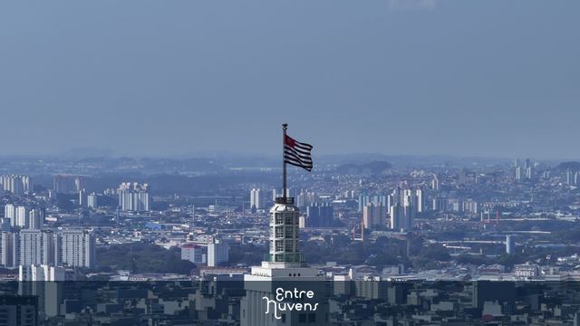 Bandeira de São Paulo no topo do edifício com metropole ao fundo