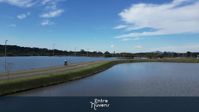Ciclovia à beira do lago em dia ensolarado CICLISTA  — vídeo aéreo de Pinhais