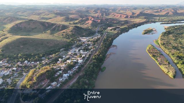 Cidade de Periquito com rio passando ao lado da linha de trem