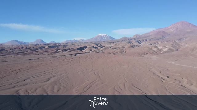 Deserto de areia com vulcão ao fundo