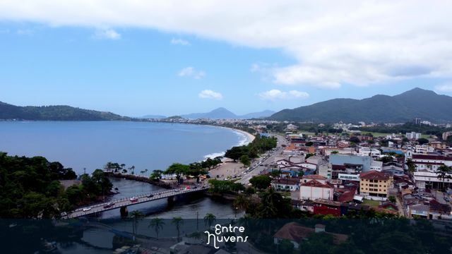 Dolly out sobre praia, rio e cidade