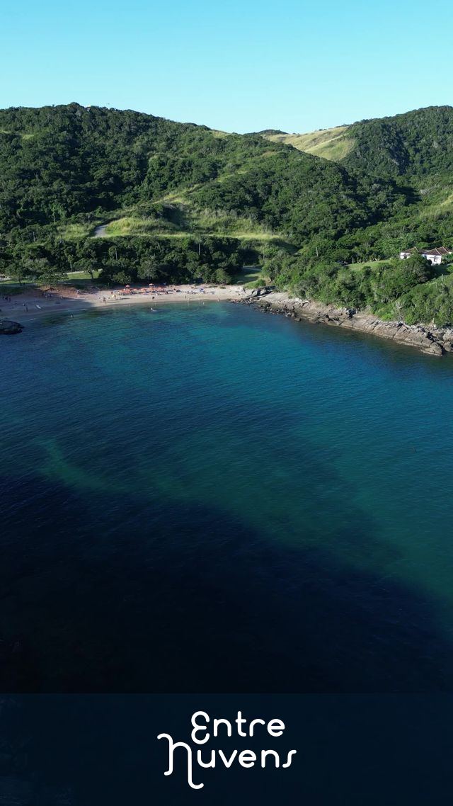 Drone com movimento lateral mostrando o mar chegando na Praia do Forno em Búzios RJ com morros verdes ao fundo — vídeo aéreo de Armação dos Búzios