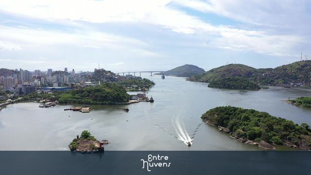 Drone em alta altitude sobre a baía de Vitória com vista para a Terceira Ponte.