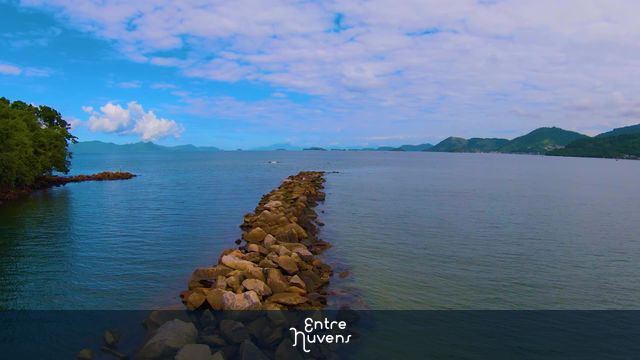 Faixa de pedra, que separa um rio de água doce, e o mar, onde pescadores ficam. — vídeo aéreo de Angra dos Reis