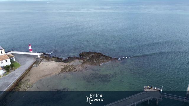 Farol listrado à beira-mar cristalino