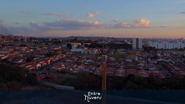 Grua (guindaste) operando na construção de condomínio residencial ao pôr do sol - 4k — vídeo aéreo de Taubaté