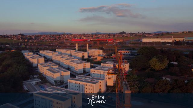 Grua (guindaste) operando na construção de condomínio residencial ao pôr do sol - 4k — vídeo aéreo de Taubaté