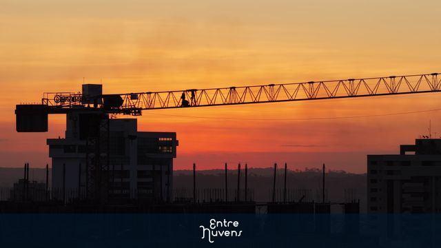 Guindaste em destaque ao pôr do sol urbano