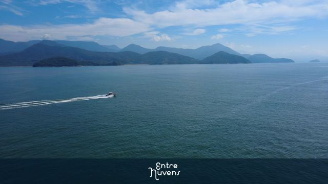 Lancha barco navegando em alta velocidade na Baía de Ubatuba, vista aérea de drone