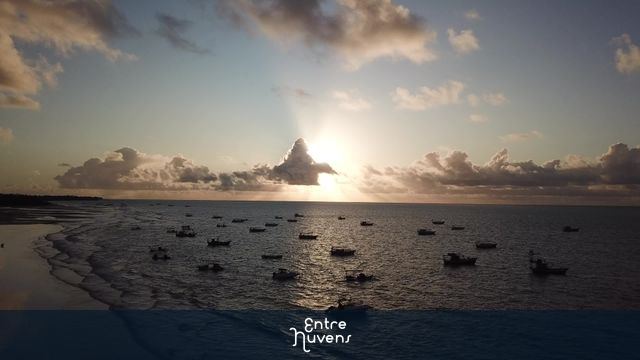 Nascer do sol lindo no mar com barquinhos
