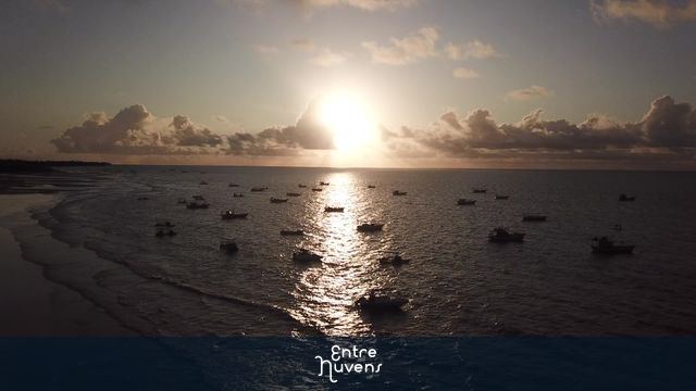 Nascer do sol no mar com barquinhos (indo em direção ao sol)
