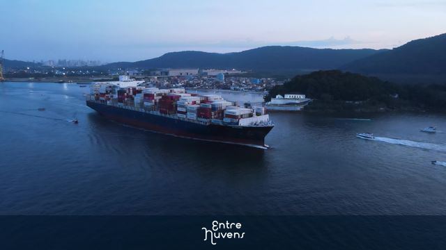 Navio cargueiro navegando pelo porto ao entardecer