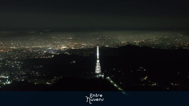 Noite de são paulo iluminada atrás do pixo do jaraguá revelando camada densa de poluição