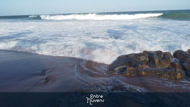 O Poder das Ondas: Mar Batendo nas Pedras da Praia